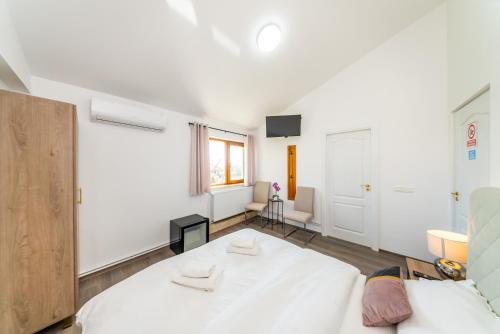 een slaapkamer met een groot wit bed en een raam bij La Casa Blanca in Vladimirescu