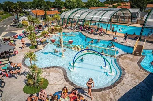 un grupo de personas en una piscina en un complejo en Camping 4 étoiles - Parc aquatique - eeiaia, en Olonne-sur-Mer