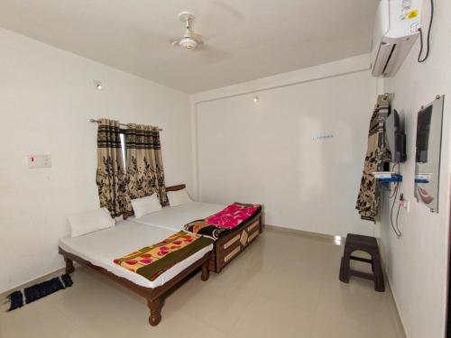 a small bedroom with a bed and a tv at Mamta Homestay in Garudeshwar