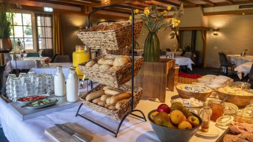 a table topped with baskets of bread and other food at Hotel de Landmarke by Flow in Groot-Agelo