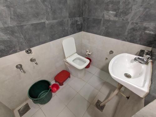a small bathroom with a toilet and a sink at Mamta Homestay in Garudeshwar