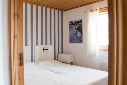 a bedroom with a bed and a striped wall at Ski-in/Ski-out | Sauna | Wi-Fi | Wood stove in Lofsdalen