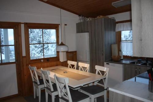 a kitchen with a table and chairs in a room at Ski-in/Ski-out | Sauna | Wi-Fi | Wood stove in Lofsdalen