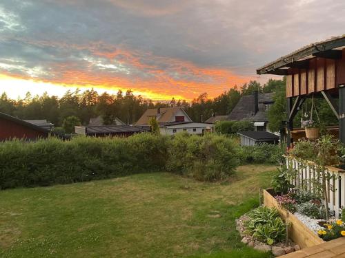 a house with a yard with a sunset in the background at Cosy villa near forest and lake in Osby