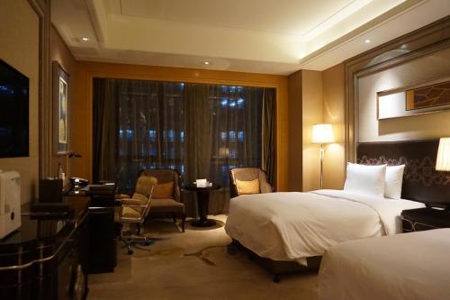 a hotel room with two beds and a window at Wanda Realm Harbin Hotel in Harbin