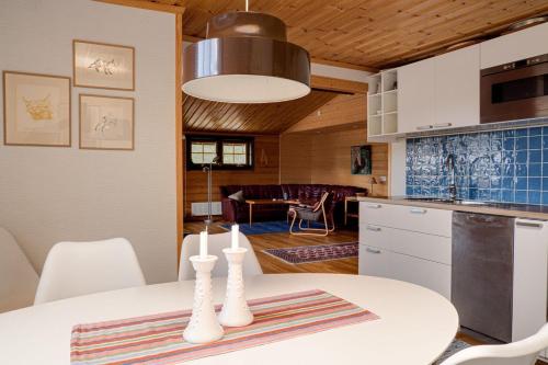 a kitchen and living room with a table and chairs at Sauna | Engine heater | Wood stove | Terrace in Lofsdalen