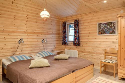 a bedroom with a bed in a wooden room at Sauna | Engine heater | Wood stove | Terrace in Lofsdalen