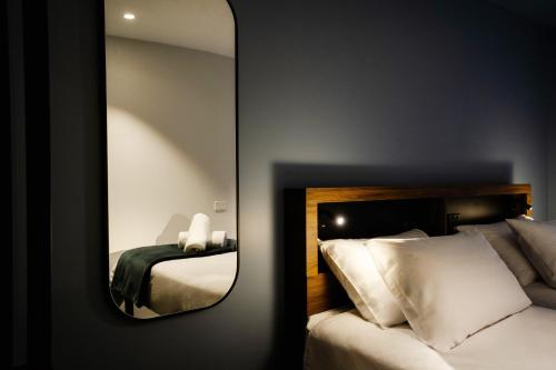 a mirror in a hotel room with a bed at Haka House Queenstown Lakefront in Queenstown