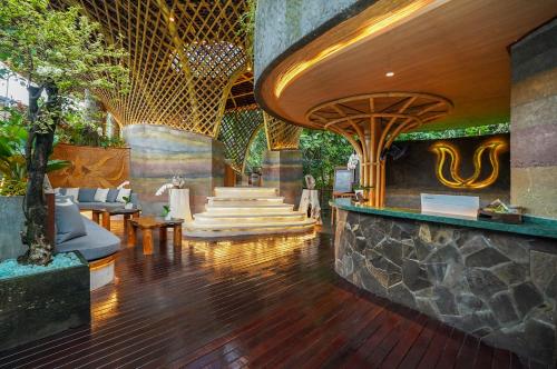 a lobby of a resort with wooden floors and stairs at Ulaman Eco Luxury Resort in Tabanan