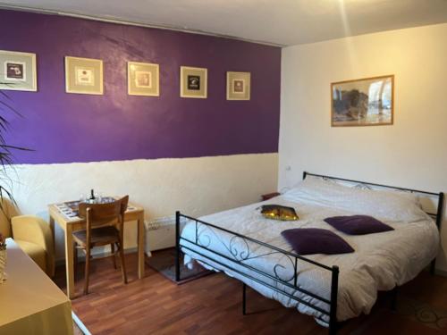 a bedroom with a bed and a table with a chair at La petite maison d issy in Issy-lʼÉvêque