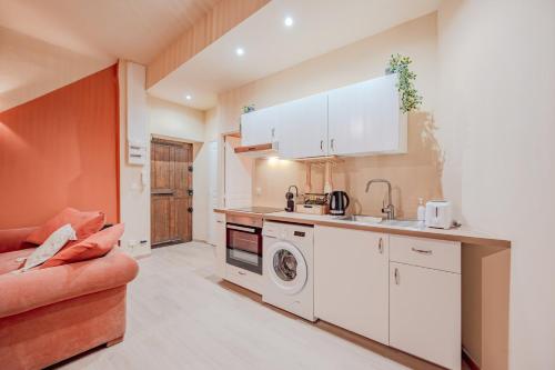 une cuisine avec une laveuse et une sécheuse à côté d'un canapé dans l'établissement T2 Bohème & Romantique - Port & Marché à Vos Pieds, à Toulon