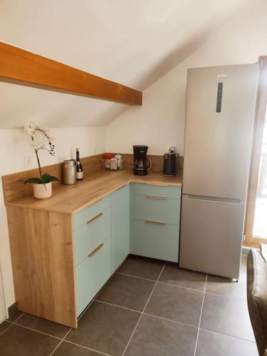 Il comprend une cuisine équipée d'un réfrigérateur et d'un comptoir en bois. dans l'établissement La Feclaz - Duplex 90m2 au pied des pistes, à Les Déserts