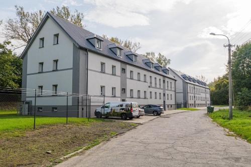 a large white building with a van parked in front of it at TVM Ostrava 1 in Ostrava