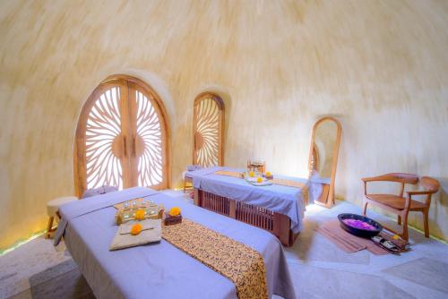 a room with two tables and two chairs and a window at Ulaman Eco Luxury Resort in Tabanan