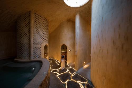 una donna in piedi in un bagno con vasca di Ulaman Eco Luxury Resort a Tabanan