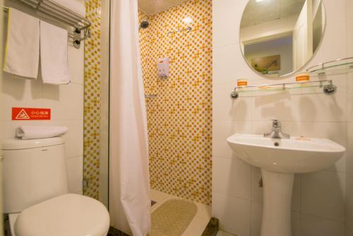 a bathroom with a toilet and a sink and a mirror at Home Inn Xi'an Giant Wild Goose Pagoda Tongyifang in Xi'an