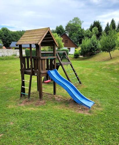 a playground with a slide and a play structure at Domov na horách - Krkonoše - horký sud, pergola, dětské hřiště - celý dům in Mřičná