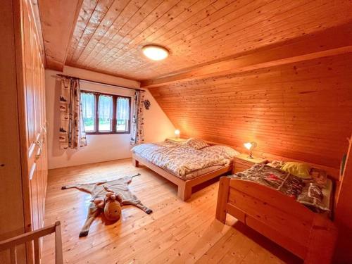 a bedroom with two beds in a log cabin at Domov na horách - Krkonoše - horký sud, pergola, dětské hřiště - celý dům in Mřičná