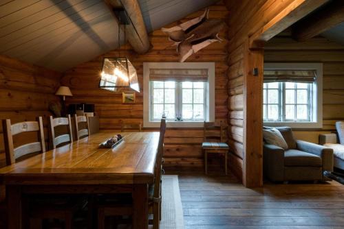 a dining room with a wooden table in a cabin at Wi-Fi | Grill | Pets allowed | Drying cabinet in Lofsdalen
