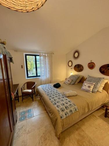 une chambre avec un grand lit et une chaise dans l'établissement Maison de charme avec piscine, à Simiane-la-Rotonde