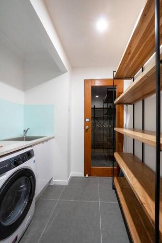a laundry room with a washer and dryer next to a door at 2BR Home with Outdoor Deck with Beach Nearby M10 in Brisbane