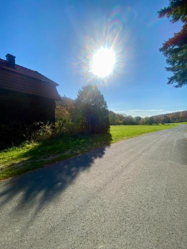 an empty road with the sun in the sky at Bienenhaus Van Sonnensee in Ritzing