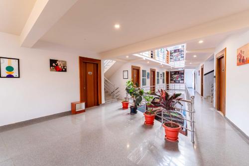 a hallway with potted plants in a building at Treebo Regalia Comforts, 15 Mins From Abbey Waterfall in Madikeri