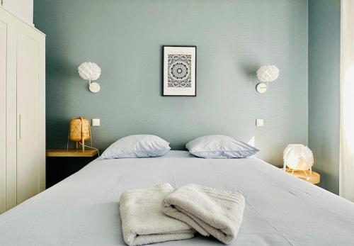 une chambre avec un lit avec des serviettes dessus dans l'établissement charmant T2 50m plage de Pontaillac, à Royan