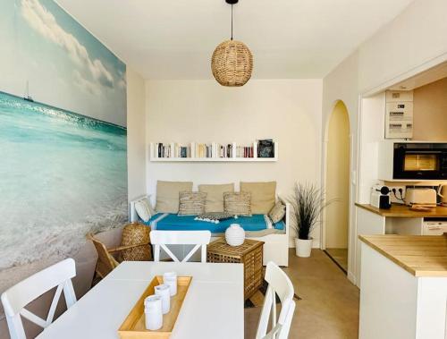 un salon avec une table et un canapé dans l'établissement charmant T2 50m plage de Pontaillac, à Royan