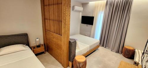 a small bedroom with two beds and a television at K35 Apartments in Preveza