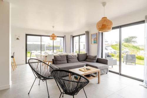 un salon avec un canapé, des chaises et une table dans l'établissement Grande maison neuve classée 4 étoiles à 300m de la mer, à Plobannalec-Lesconil