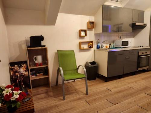 a kitchen with a green chair in a room at Cosy Duplex proche Paris in Épinay-sur-Seine