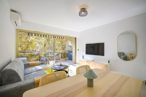 un salon avec un canapé et une table dans l'établissement Beau 2 pièces Le Silvaplana 200m des plages, à Antibes