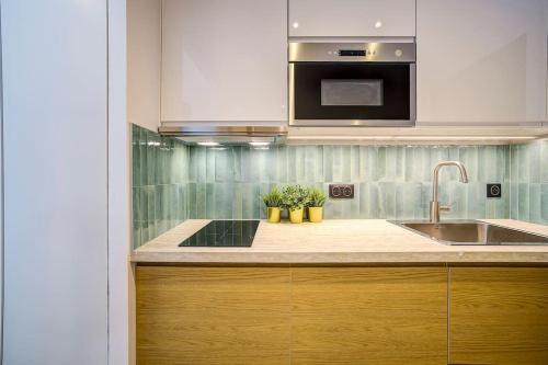 une cuisine avec un évier et un micro-ondes dans l'établissement Beau 2 pièces Le Silvaplana 200m des plages, à Antibes