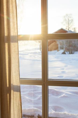 a window with a view of a snow covered yard at STF Undersvik Gårdshotell & Vandrarhem in Vallsta