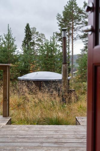 a bath tub sitting in the middle of a field at Hot tub | Sauna | WiFi | Pets allowed in Lofsdalen