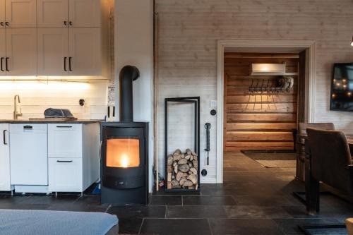 a stove with a pile of fire wood in a kitchen at Hot tub | Sauna | WiFi | Pets allowed in Lofsdalen