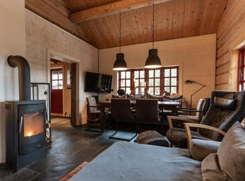 a living room with a wood stove and a dining room at Hot tub | Sauna | WiFi | Pets allowed in Lofsdalen