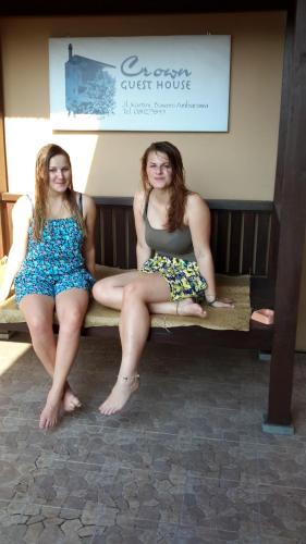 two girls are sitting on a bench at Crown Guest House in Ambarawa