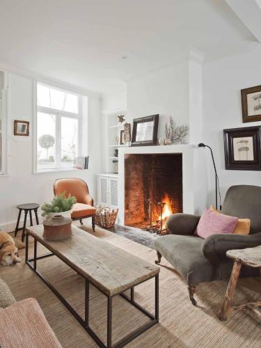 a living room with a couch and a fireplace at Guesthouse Groeninghe in the centre of Bruges in Bruges