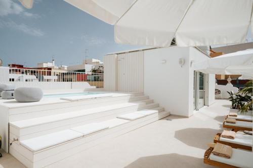 a living room with white furniture and a swimming pool at Emblemático F24-Only Adults B&B in Santa Cruz de Tenerife
