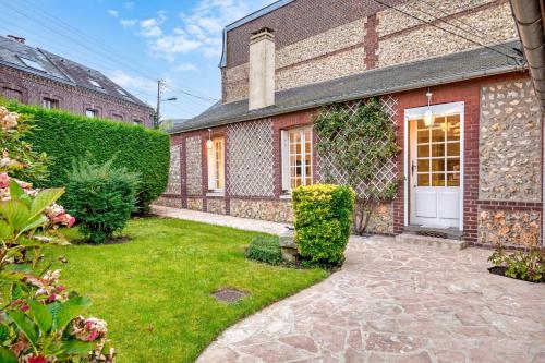 une maison en briques avec une cour dotée d'une porte blanche dans l'établissement Gisèle charmante maison de ville au coeur de Bihorel, à Bihorel