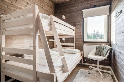 a bedroom with two bunk beds and a chair at Sauna | Wi-Fi | Chromecast | Ski shed | Wood stove in Lofsdalen