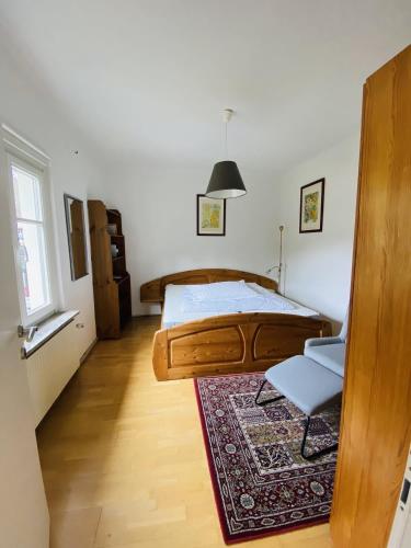 a bedroom with a bed and a chair and a rug at Appartement Cseho in Murau