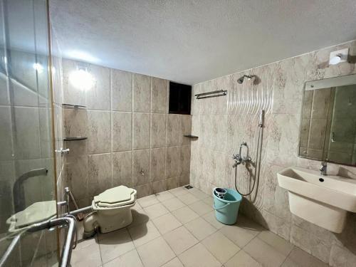 a bathroom with a shower and a toilet and a sink at Zeno Villa Malpe - Premium Villa in Malpe