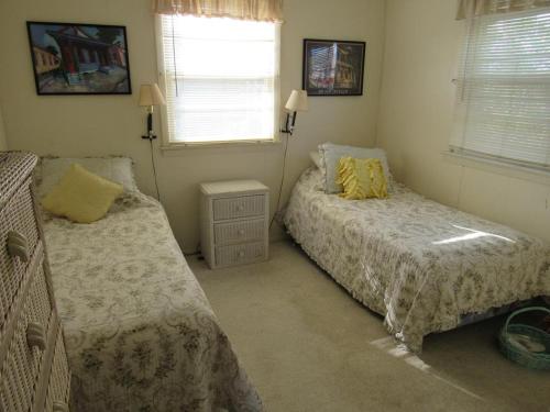 a bedroom with two beds and two windows at Lagoon Front Home In Harvey Cedars in Harvey Cedars