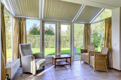 a living room with chairs and a table and windows at Vesting de Bronsbergen in Zutphen