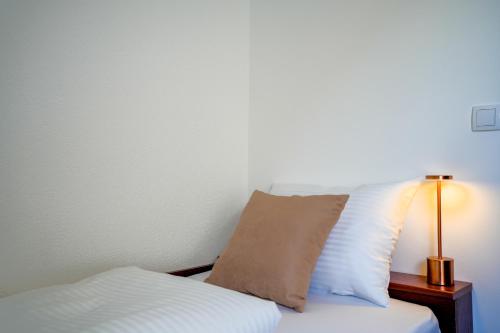 a bed with a pillow and a lamp on it at Attache Vila in Kruševac