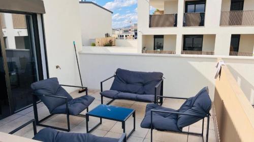three chairs and a table on a balcony at Appartement Luxueux de haut standing au cœur de Lyon avec une terrasse in Lyon