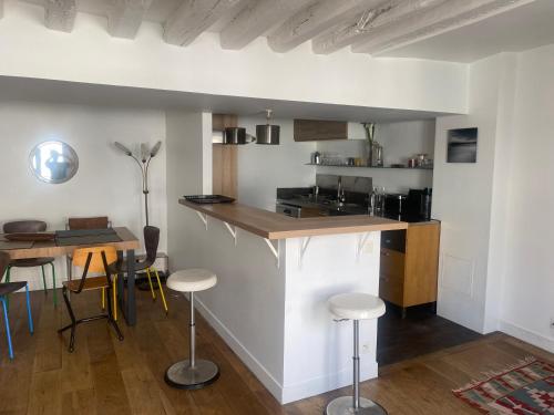 une cuisine avec un comptoir et une table avec des tabourets dans l'établissement ParisLouvreSamaritaineCharme, à Paris